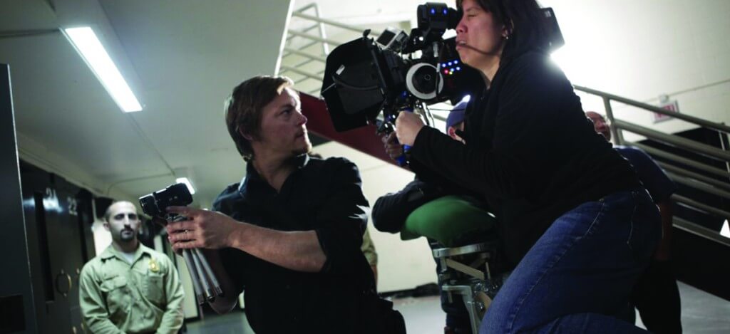 A film crew operates a camera on a set