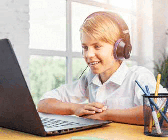 Young boy with headset at laptop for online class